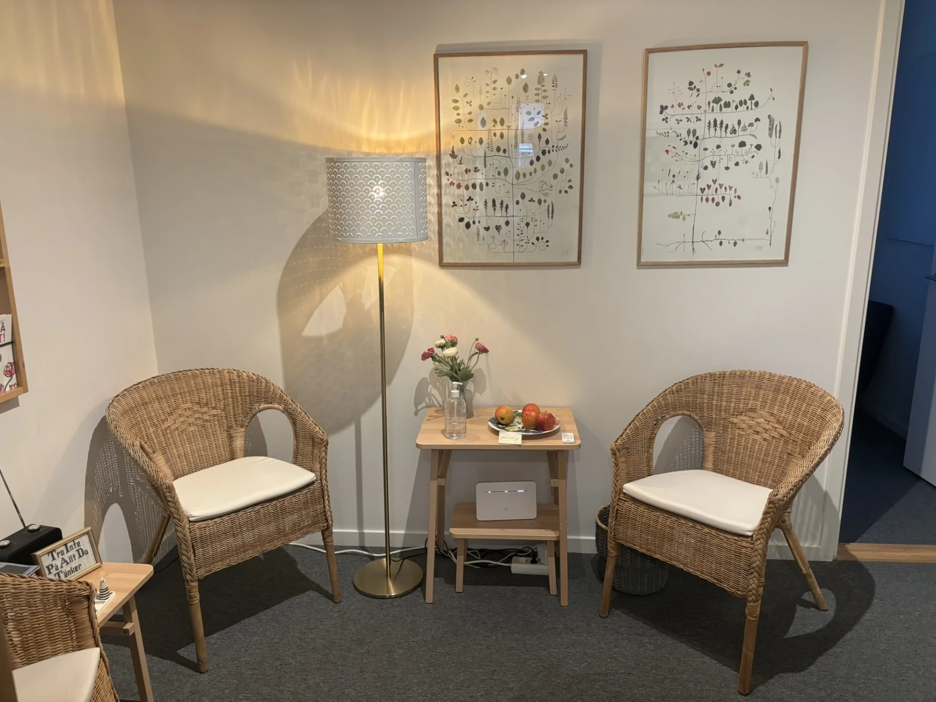 Två rottingfåtöljer och ett litet bord med blommor i VIQI:s mottagning