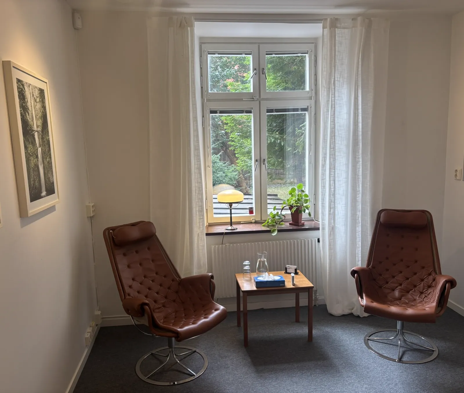 VIQI:s mottagning på Grev Turegatan 63 i Stockholm med två bruna fåtöljer och ett litet bord.